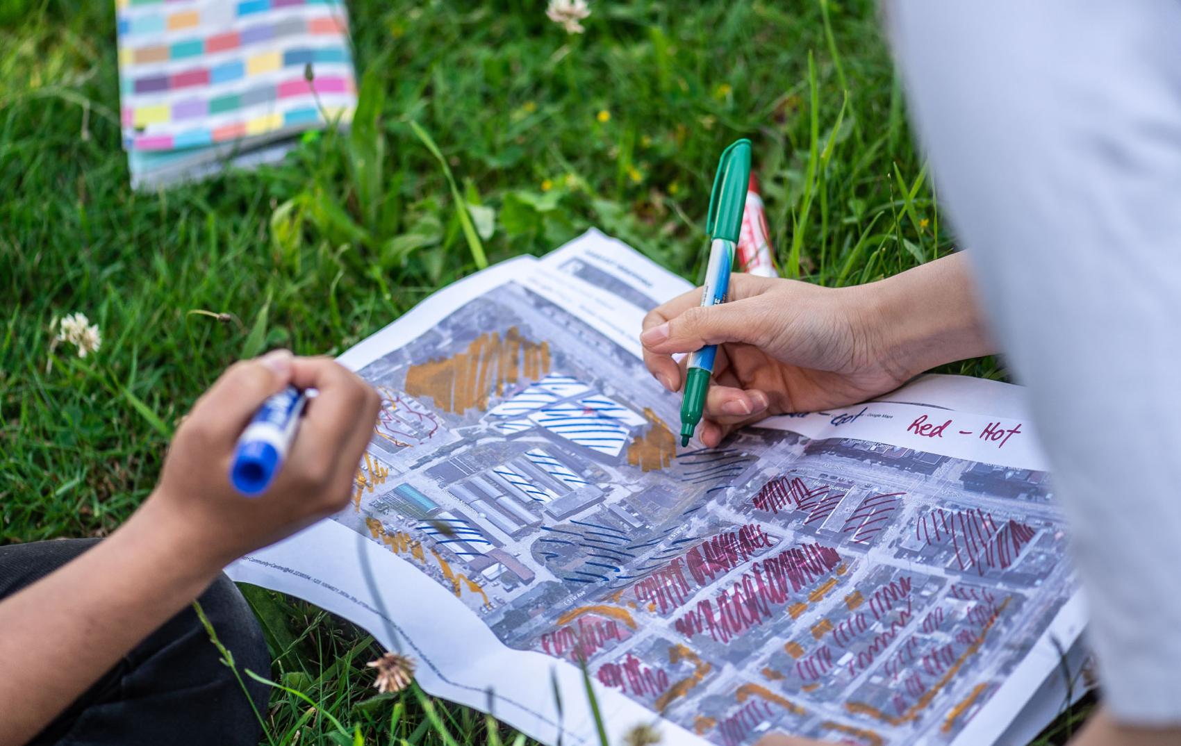Two people look at a map of the neighbourhood to determine where it is vulnerable to climate change dangers