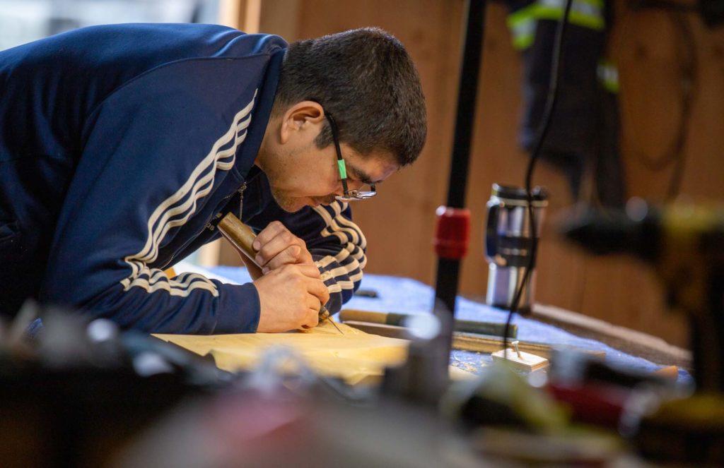 Musqueam artist Brett Sparrow carves ʔəlqsən in his workshop