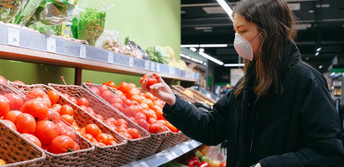 A women looks at tomatoes in a store