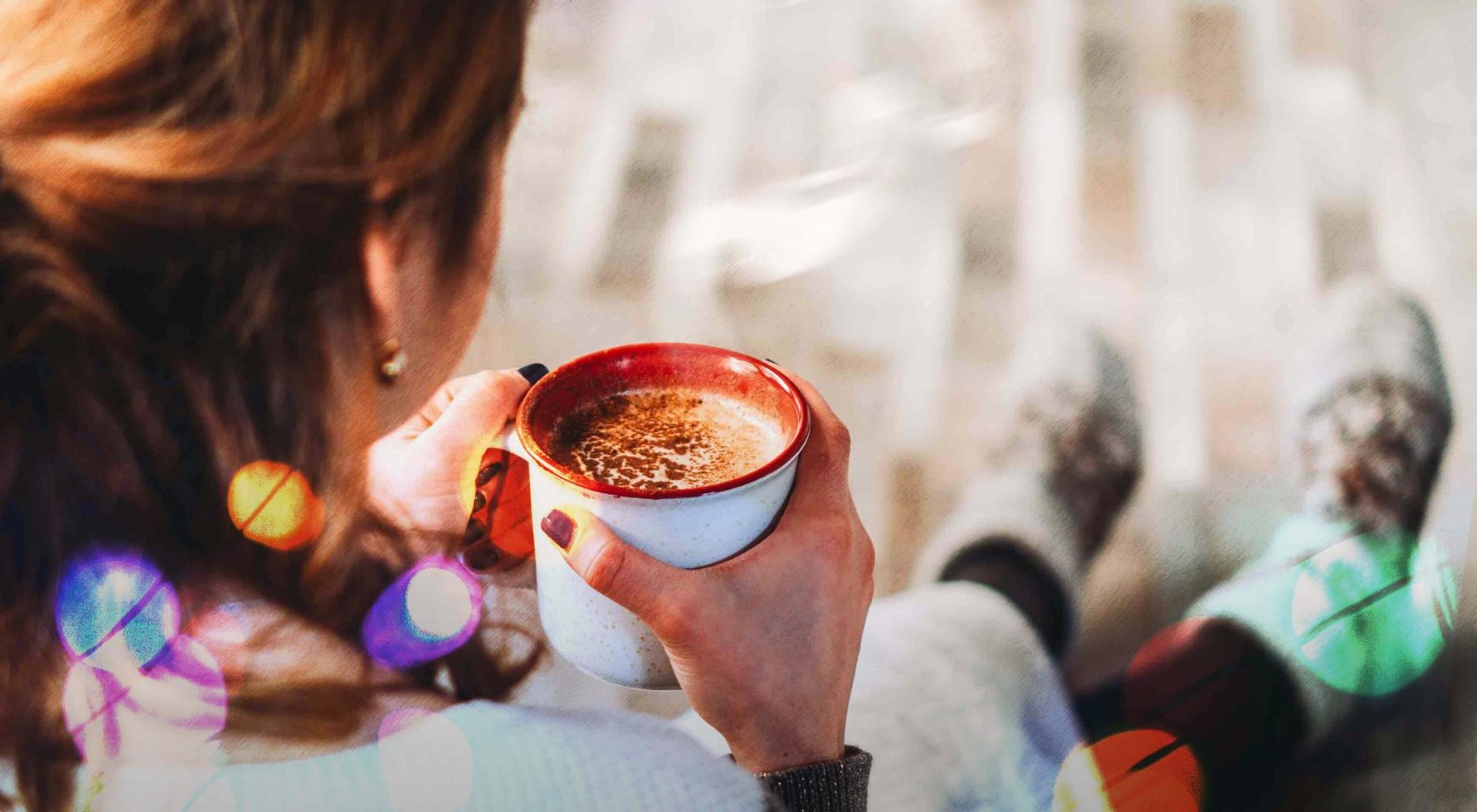 A women drinks hot chocolate to improve her mental health over the holiday season