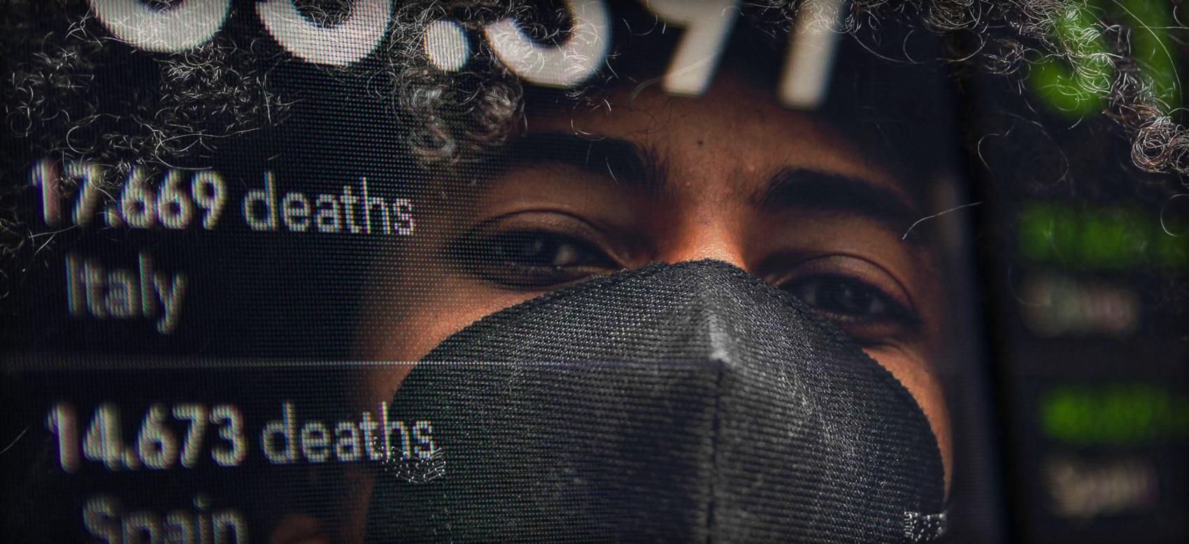 Photo illustration of a young adult wearing a mask. Young adults have been unfairly blamed for COVID-19 spread.