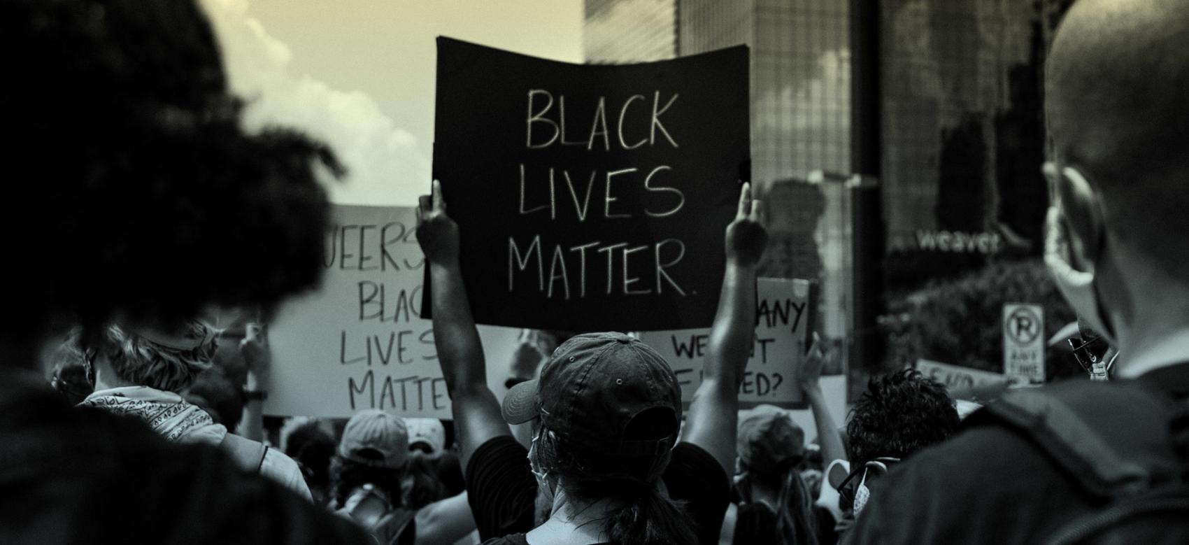 A group of people holds anti-racist signs at a Black Lives Matter protest