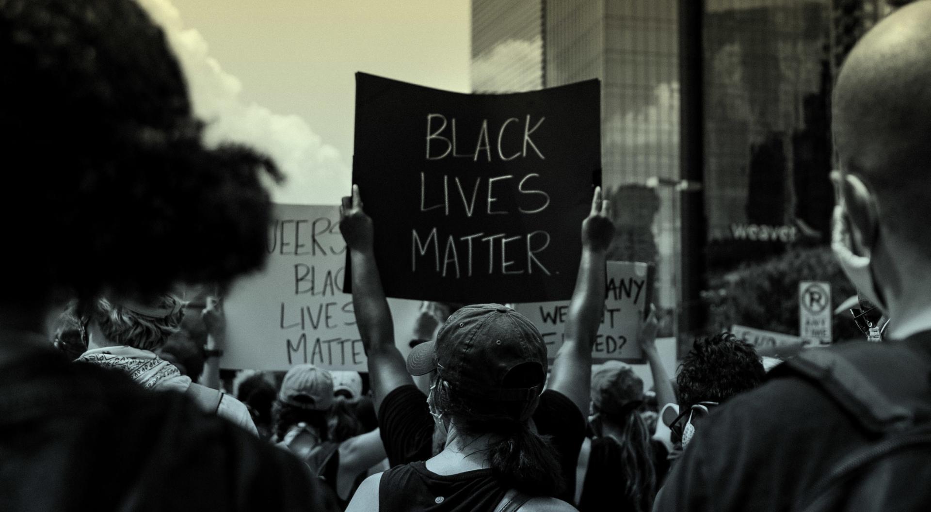 A group of people holds anti-racism signs at a Black Lives Matter protest