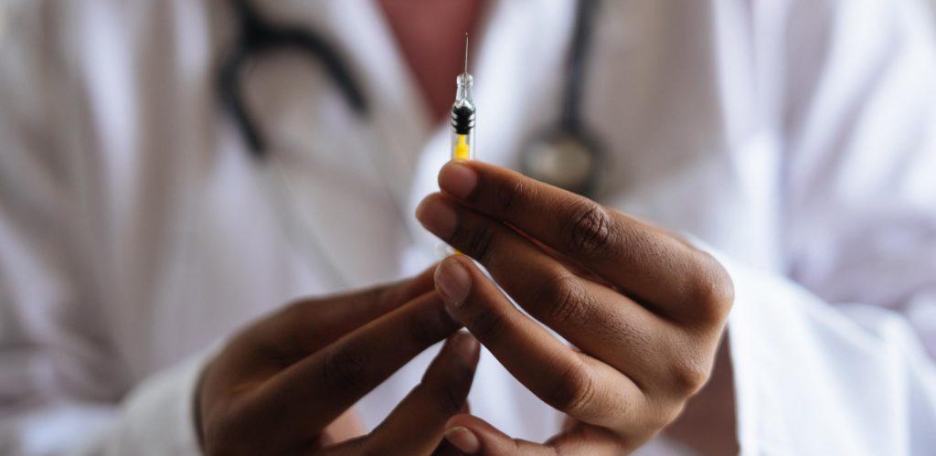 A medical professional prepares a syringe with the COVID-19 vaccine.