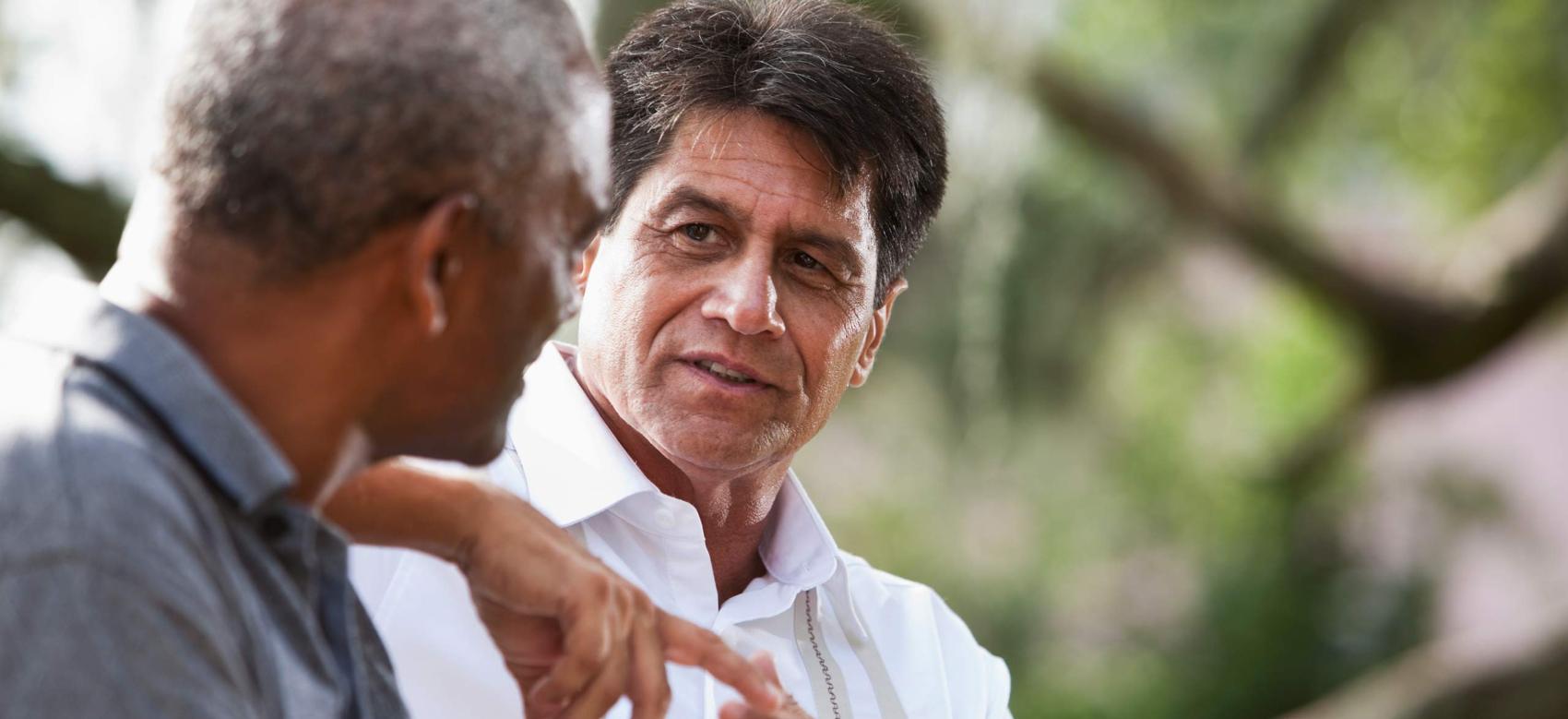 Two people sitting outside and having a discussion about mental health.