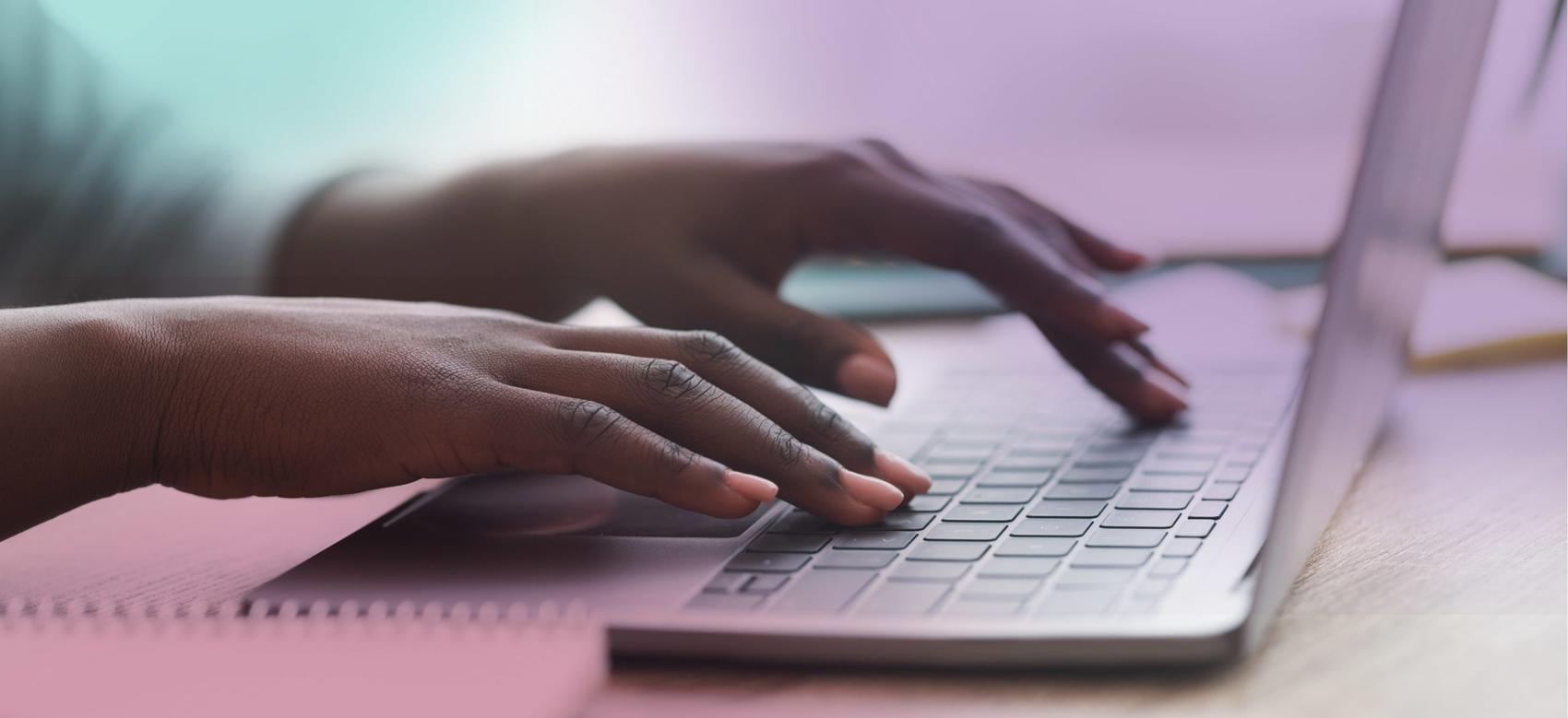 A pair of young hands on laptop writing