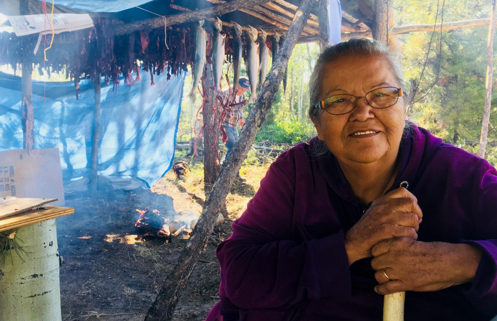 Indigenous elder smoking salmon