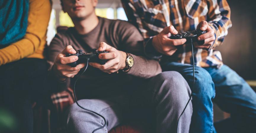 3 people sitting on the couch playing a video game.