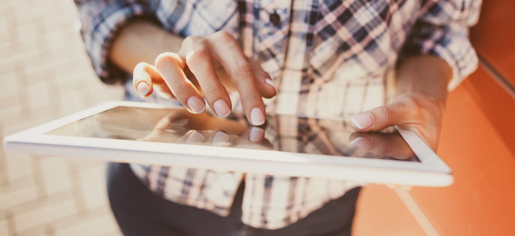 A photo of a young woman's hands using social media on an tablet