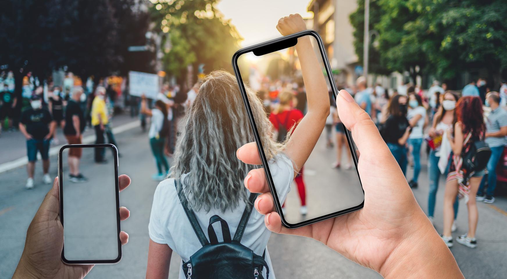 Taking pictures of young woman raising her fist up with phones