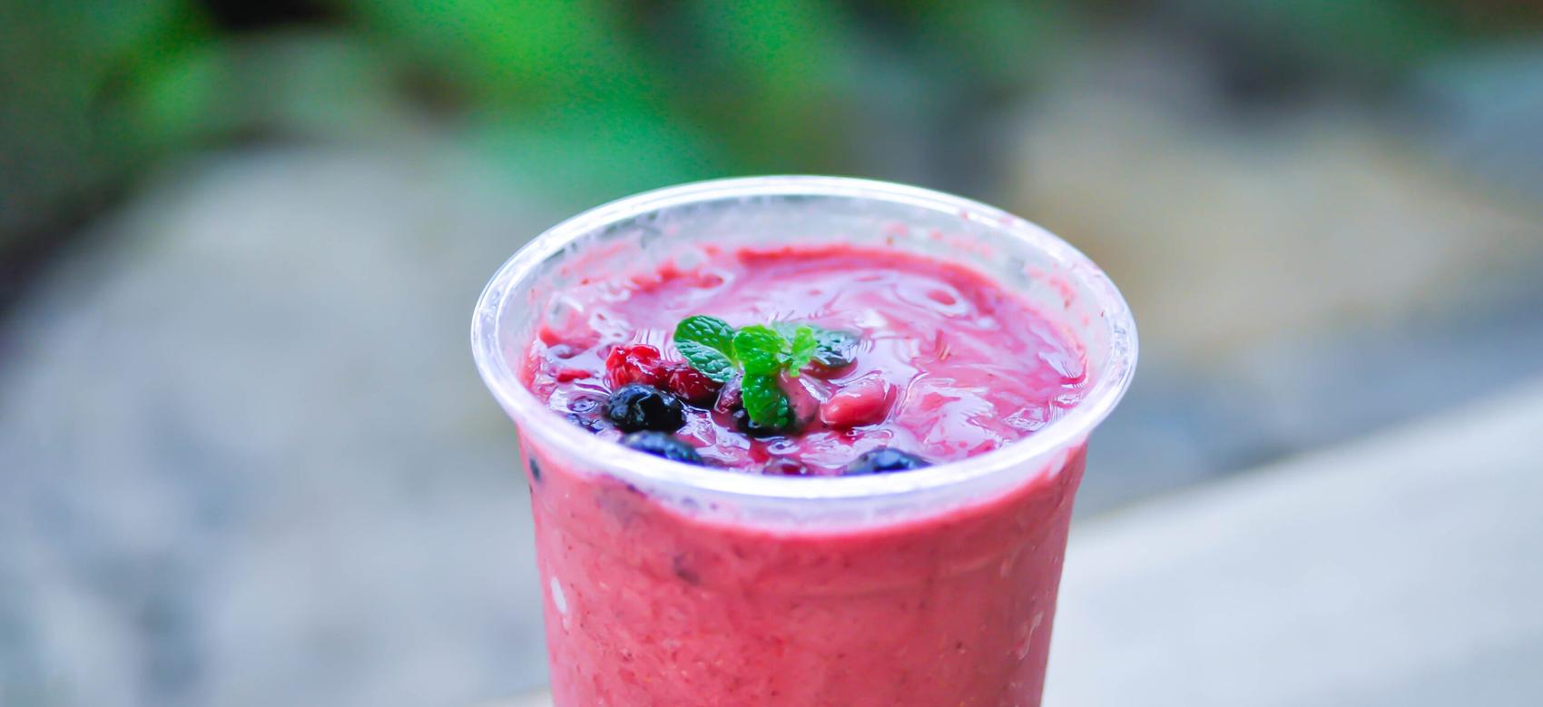 A berry smoothie cup on a table.