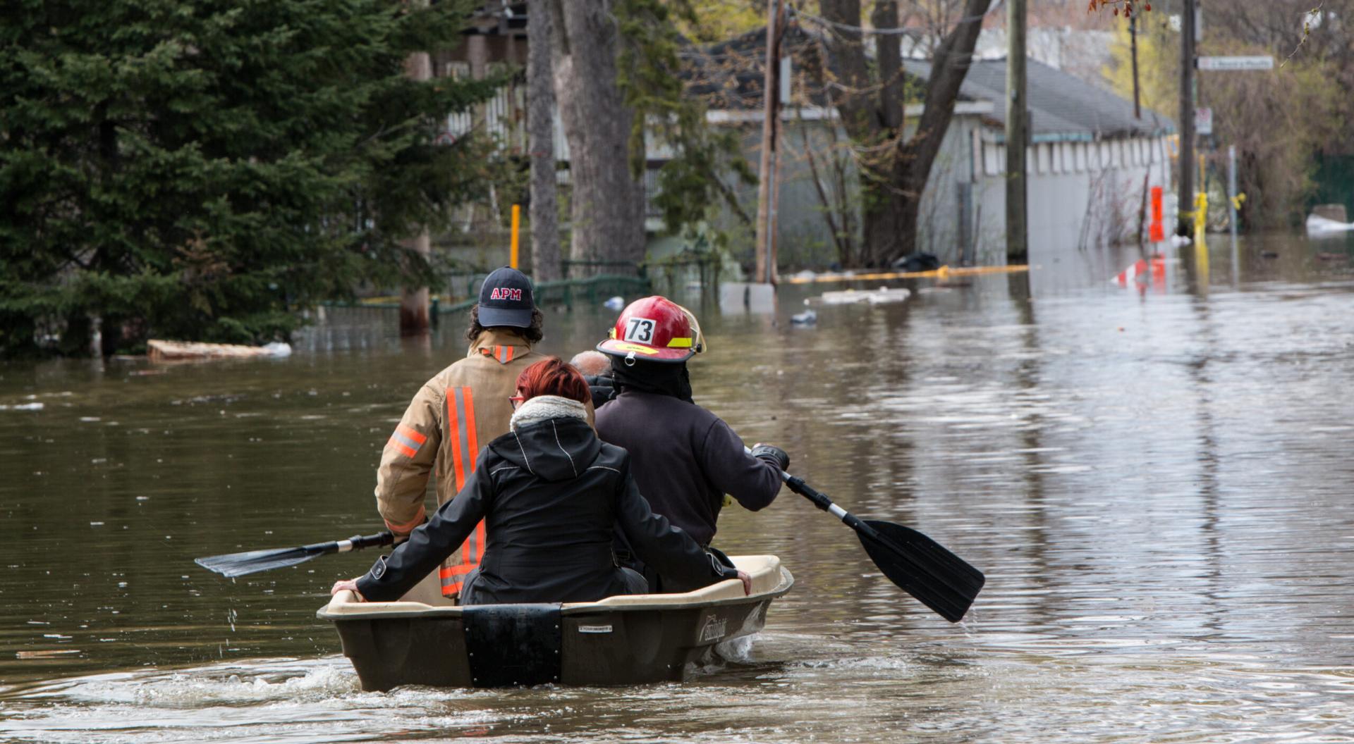 Fireman rescue an old couple from their flooded house with a boat. On Cousineau St., in the Ahuntsic-Cartierville borough, Montreal, the river rose and flooded the street and a dozen of houses.