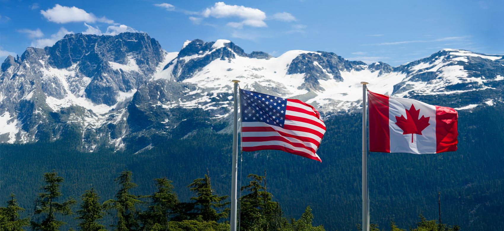 Canadian and American flags in the mountains