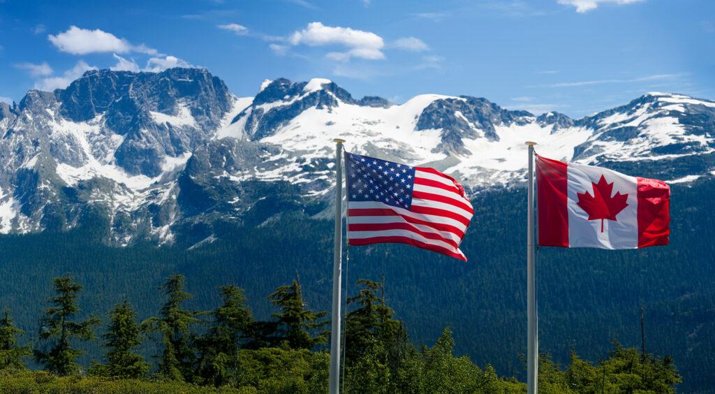 Canadian and American flags in the mountains